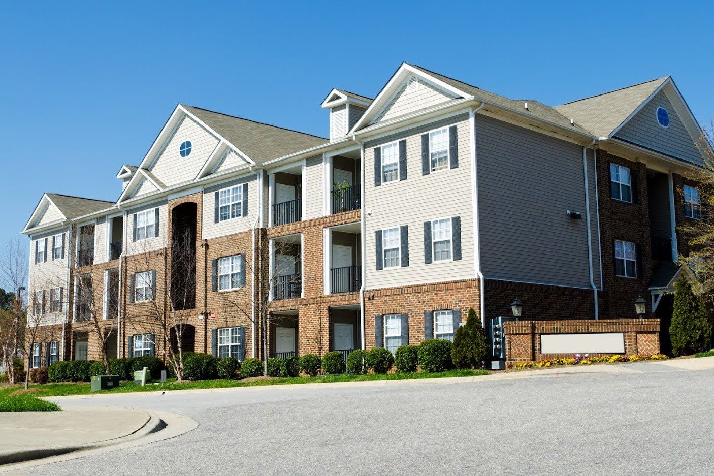 a large brick building with grass in front of a house